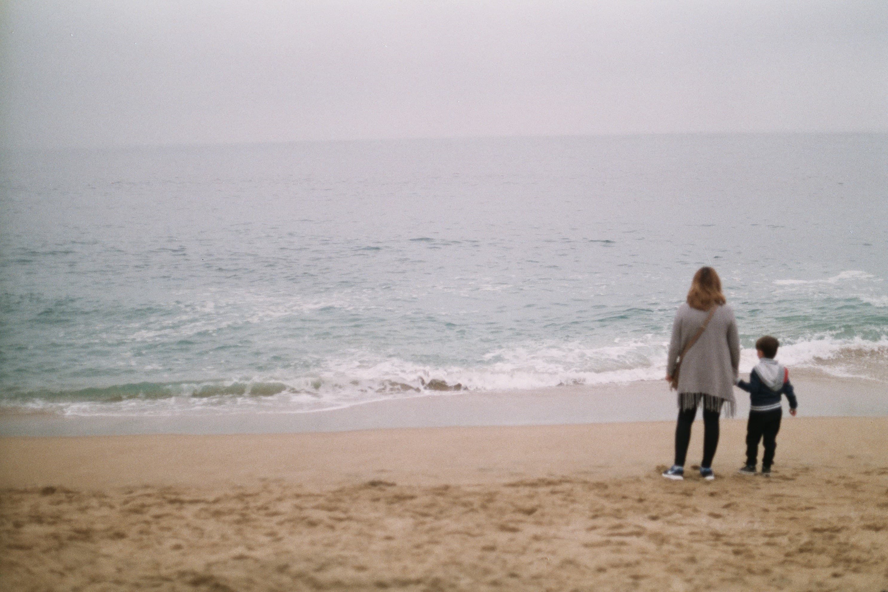Parent and child walking on beach - representing protective parents